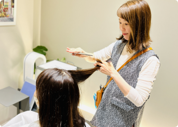 美容室で2人の女性スタッフが1人の女性スタッフをシャンプーの指導・チェックをしている様子